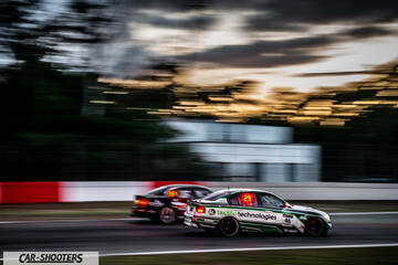 rear three-quarter, white on a race track at dusk