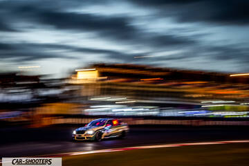 front three-quarter, on a racetrack at dusk with motion blur