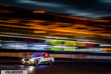 front three-quarter, multicolor on a racetrack at night with motion blur