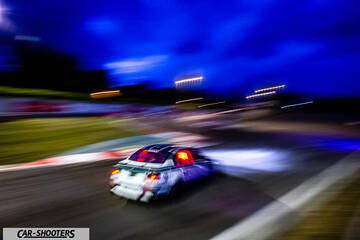 rear three-quarter, white with graphics on a race track at night