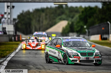 front three-quarter, white with green and black livery on a race track
