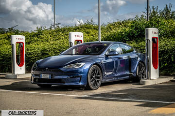Tesla Model S Plaid – front three-quarter, blue at a charging station