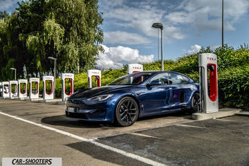Tesla Model S Plaid – front three-quarter, blue at a supercharger station