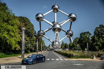 Tesla Model S Plaid – front three-quarter, blue against a large landmark monument backdrop