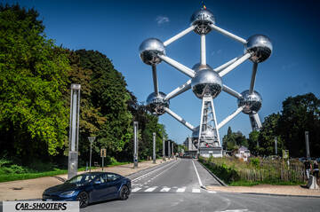 Tesla Model S Plaid – front three-quarter, dark blue against the atomium landmark