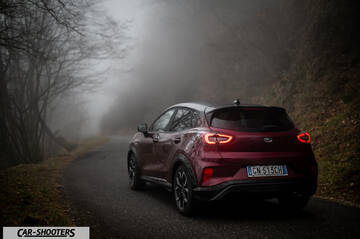 Ford Puma STLine – rear three-quarter, dark red metallic on a foggy mountain road