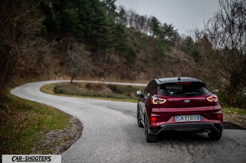 Ford Puma STLine – rear view, dark red metallic on a winding country road