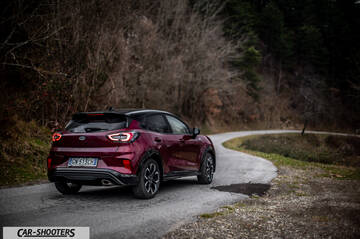 Ford Puma STLine – rear three-quarter, dark red metallic on a winding country road