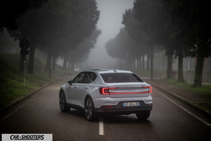 Polestar 2 – rear three-quarter, white on a foggy road lined with trees