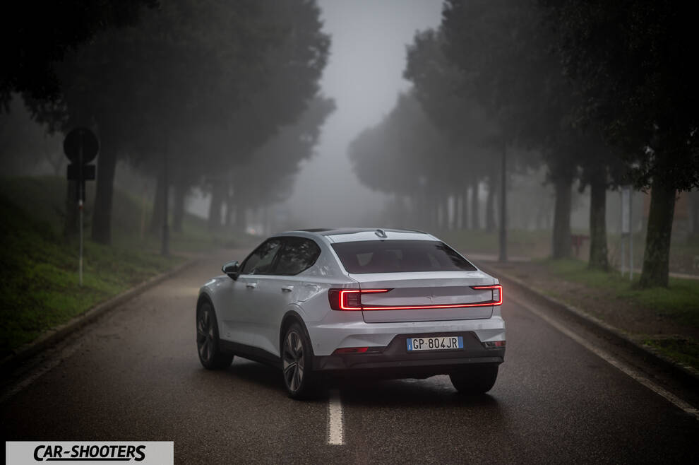 Polestar 2 – rear three-quarter, white on a foggy road lined with trees