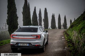Polestar 2 – rear three-quarter, white on a country road lined with tall trees
