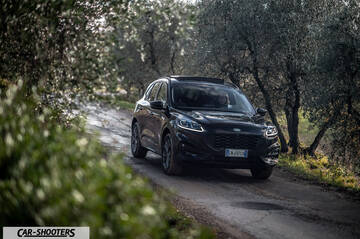 Ford Kuga STLine – front three-quarter, black on a narrow tree-lined road