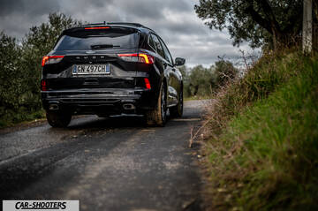 Ford Kuga STLine – rear three-quarter, black on a country road
