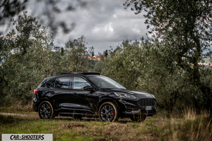 Ford Kuga STLine – front three-quarter, black on a dirt road among trees