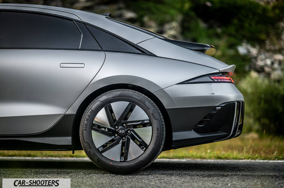 Hyundai Ioniq 6 – rear three-quarter, matte grey against a mountain backdrop