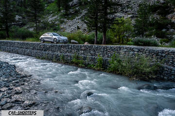 Hyundai Ioniq 6 – front three-quarter, silver parked near a rushing river