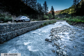 Hyundai Ioniq 6 – rear three-quarter, silver parked near a river in the mountains