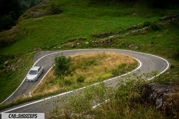 Hyundai Ioniq 6 – front three-quarter, silver on a mountain road hairpin turn