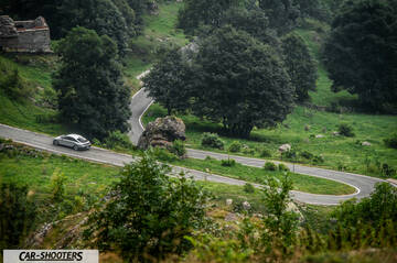 Hyundai Ioniq 6 – rear three-quarter, silver on a winding mountain road