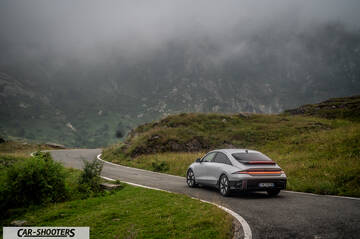 Hyundai Ioniq 6 – rear three-quarter, silver on a winding mountain road