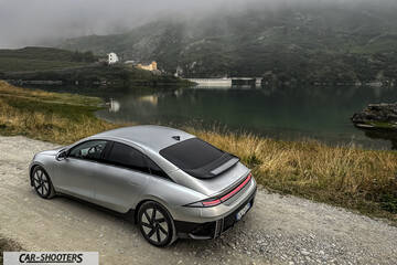 Hyundai Ioniq 6 – rear three-quarter, silver metallic against a mountain lake backdrop