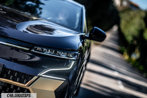 Renault Megane E TECH – front three-quarter, dark blue on a tree lined road