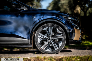Renault Megane E TECH – side profile, dark blue dark blue against a rural backdrop