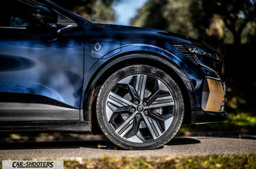 Renault Megane E TECH – side profile, dark blue dark blue against a rural backdrop