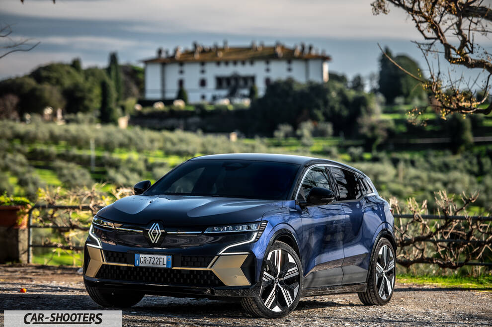 Renault Megane E TECH – front three-quarter, blue against a villa backdrop