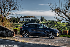 Renault Megane E TECH – side profile, dark blue on a country road with a villa in the background