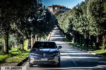 Renault Megane E TECH – front three-quarter, dark blue on a tree lined road