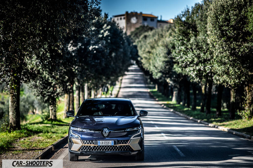 Renault Megane E TECH – front three-quarter, dark blue on a tree lined road