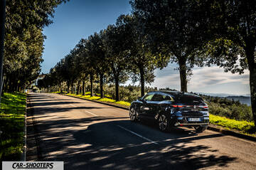Renault Megane E TECH – rear three-quarter, dark blue on a tree-lined road