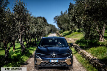 Renault Megane E TECH – front three-quarter, dark blue on a country road