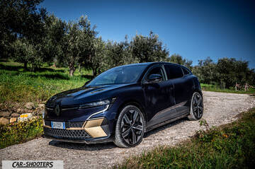 Renault Megane E TECH – front three-quarter, dark blue on a dirt road