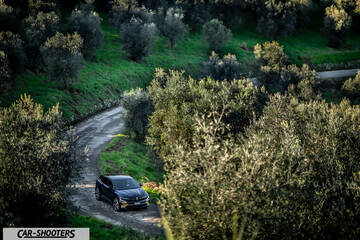 Renault Megane E TECH – front three-quarter, dark blue on a winding country road