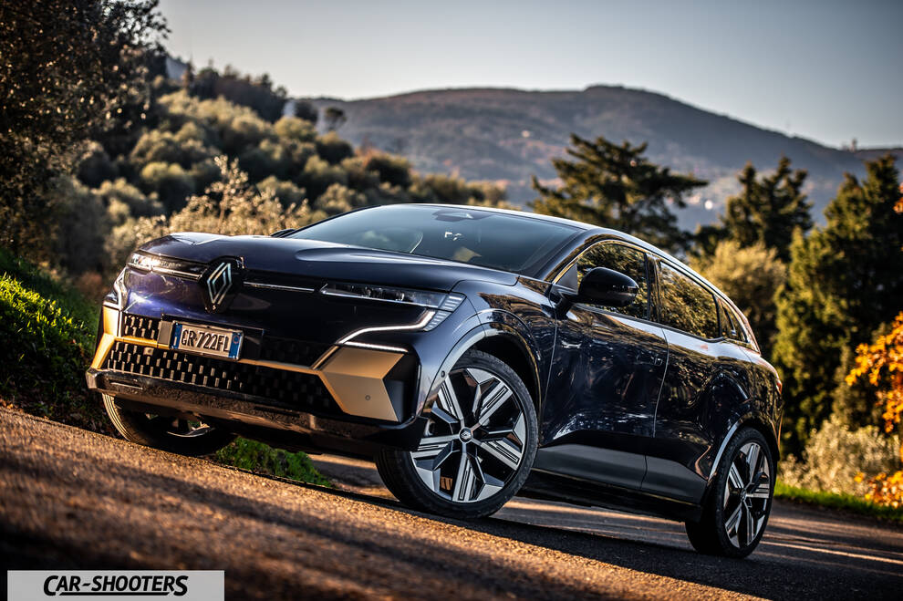 Renault Megane E TECH – front three-quarter, dark blue against a mountain backdrop