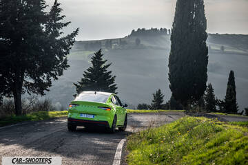 Skoda Enyaq – rear three-quarter, bright green on a country road