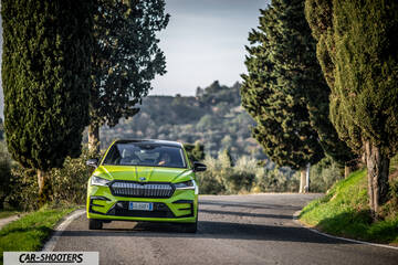 Skoda Enyaq – front three-quarter, yellow-green on a winding country road