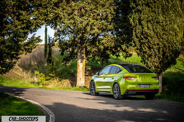 Skoda Enyaq – rear three-quarter, lime green on a country road