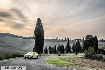 Skoda Enyaq – front three-quarter, yellow-green on a winding country road