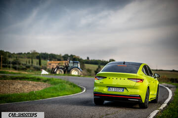 Skoda Enyaq – rear three-quarter, yellow-green on a country road