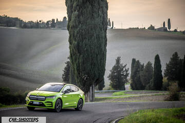 Skoda Enyaq – front three-quarter, bright green on a winding country road