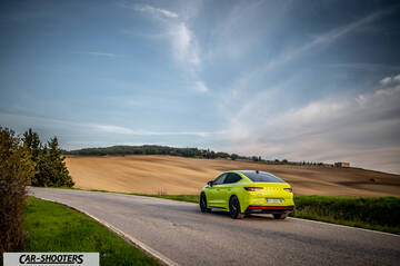 Skoda Enyaq – rear three-quarter, yellow on a country road