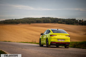 Skoda Enyaq – rear three-quarter, yellow on a country road