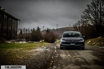 Tesla Model 3 2025 – front three-quarter, dark grey on a country road