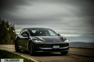 Tesla Model 3 2025 – front three-quarter, dark grey on a country road