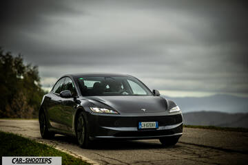 Tesla Model 3 2025 – front three-quarter, dark grey on a country road
