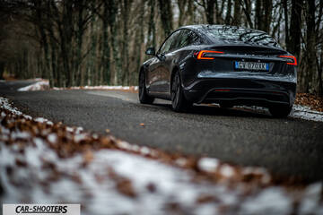 Tesla Model 3 2025 – rear three-quarter, dark grey on a snowy country road