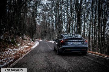 Tesla Model 3 2025 – rear view, dark grey on a winding forest road